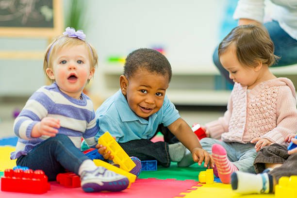 Toddlers playing with colorful learning materials in a childcare classroom
